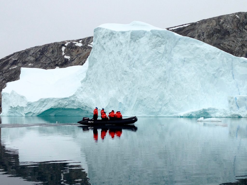 zodiac beside an iceberg in Sermilik Fjord, Greenland